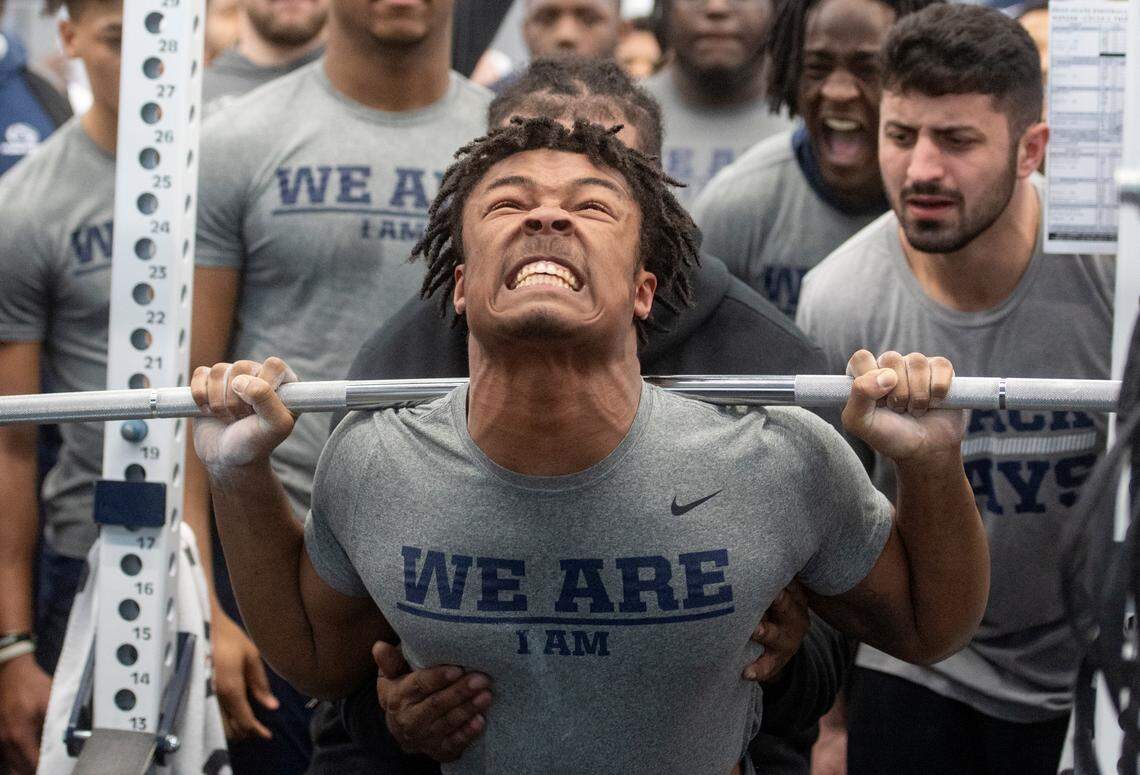 Teammates cheer on Penn State linebacker Keon Wylie as he squats during a max-out lifting session on Thursday, March 2, 2023.