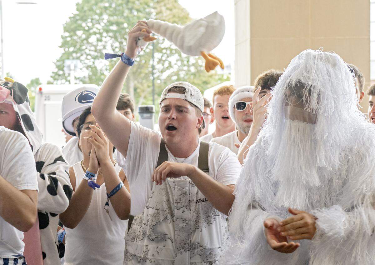 A student waves a stuffed duck in the air as the Nittanyville campers wait to be let into Beaver Stadium for the Penn State football game against Oregon on Saturday, Sept. 27, 2025.  
