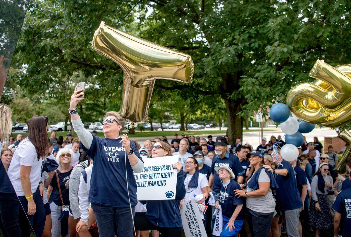 Penn State Vice President of Intercollegiate Athletics Sandy Barbour takes a selfie with the crowd before the “Roar and Rally” walk to celebrate the 50th Anniversary of Title IX on Thursday, June 23, 2022.