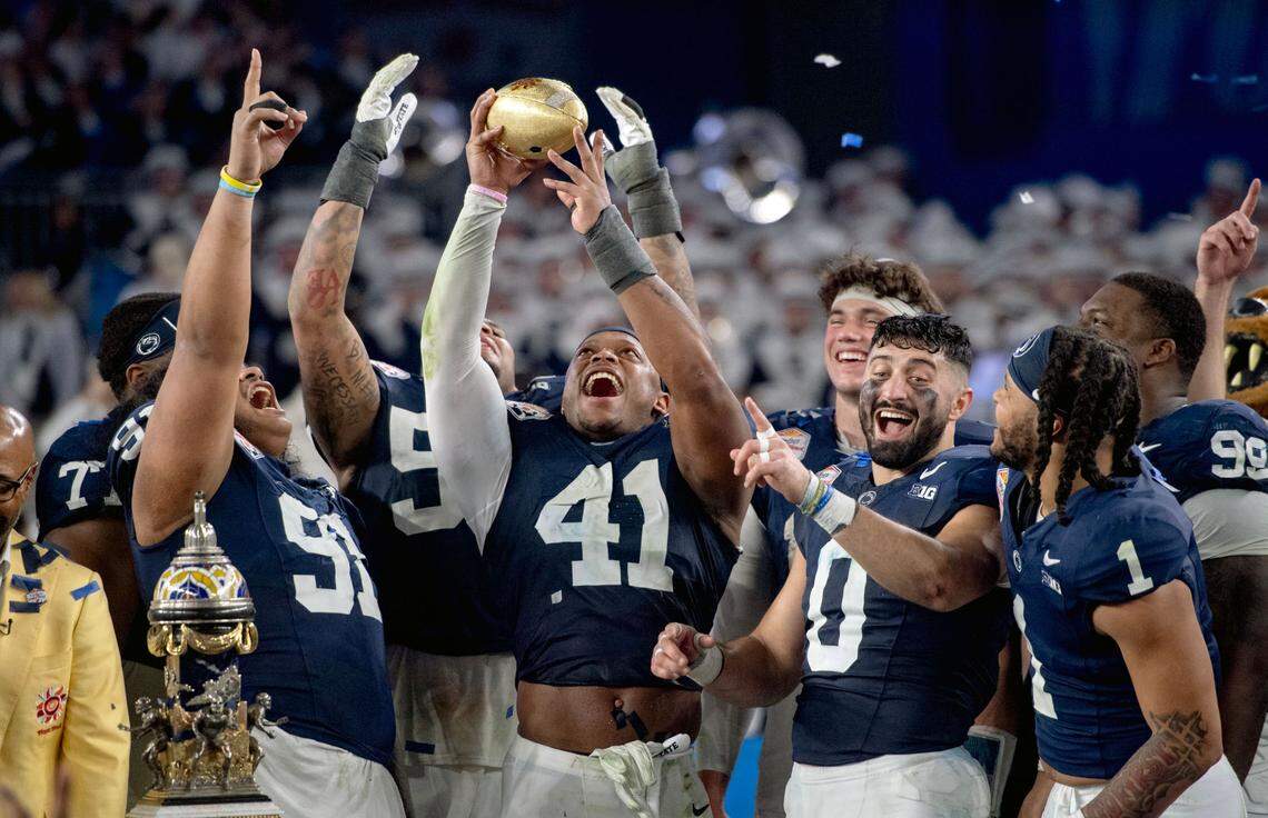 Penn State linebacker Kobe King holds up the Fiesta Bowl trophy after beating Boise State 31-14 on Tuesday, Dec. 31, 2024 at State Farm Stadium.