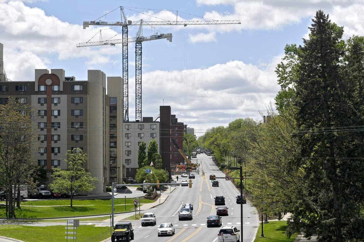 In this photo from 2017, cars travel into downtown State College as cranes work on the Rise on the corner of College Avenue and High Street.