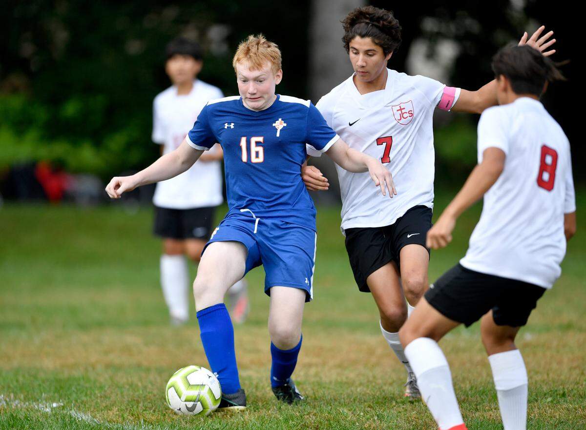 Saint Joseph’s Catholic Academy’s Fletcher Hess clears the ball from a Juniata Christian School player during the game on Thursday, Sept. 9, 2021.