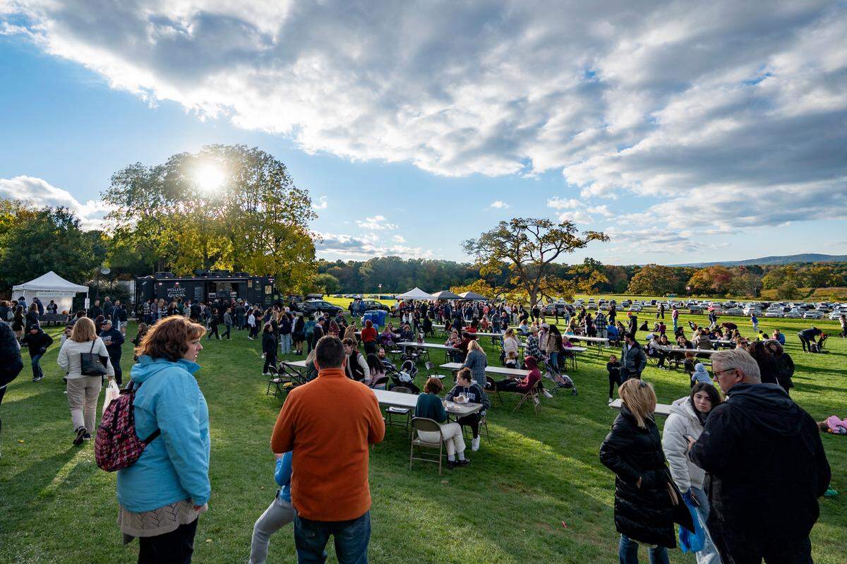 The sun starts to set as visitors stop by the food court at The Arboretum at Penn State Pumpkin Festival on Saturday, Oct. 8, 2022.
