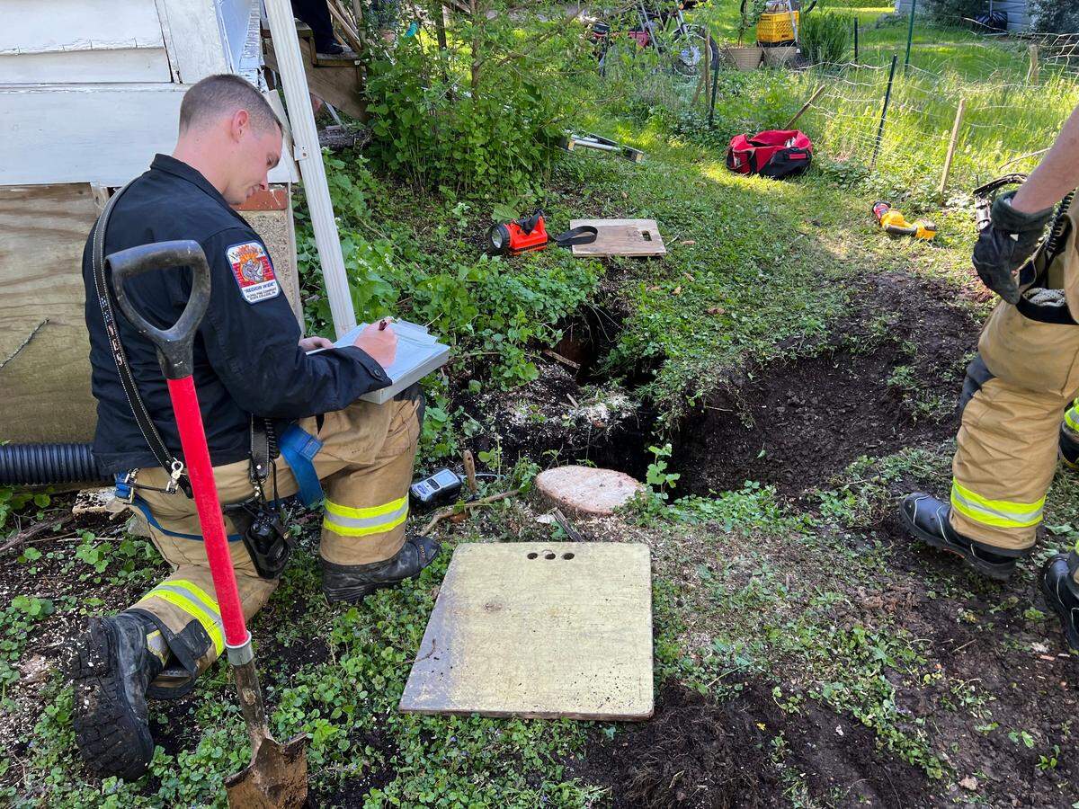Alpha Fire Company firefighters work to rescue a corgi who fell into a sinkhole in College Township on Wednesday, May 11, 2022.