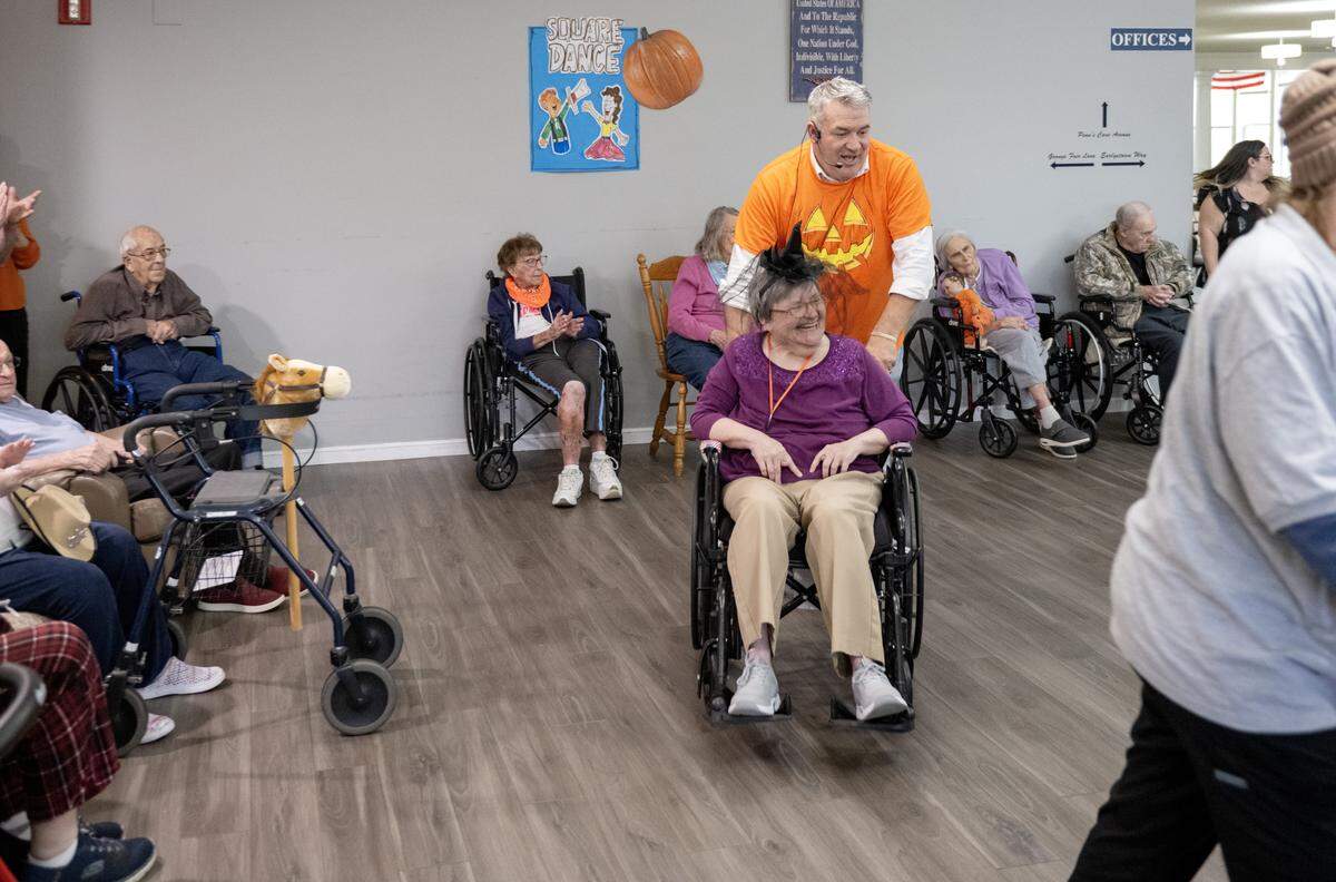 Amy Ripka laughs as she is pushed in her wheelchair by Cory Geishauser during square dancing at the Wynwood House in Centre Hall on Thursday, Oct. 30, 2025. 