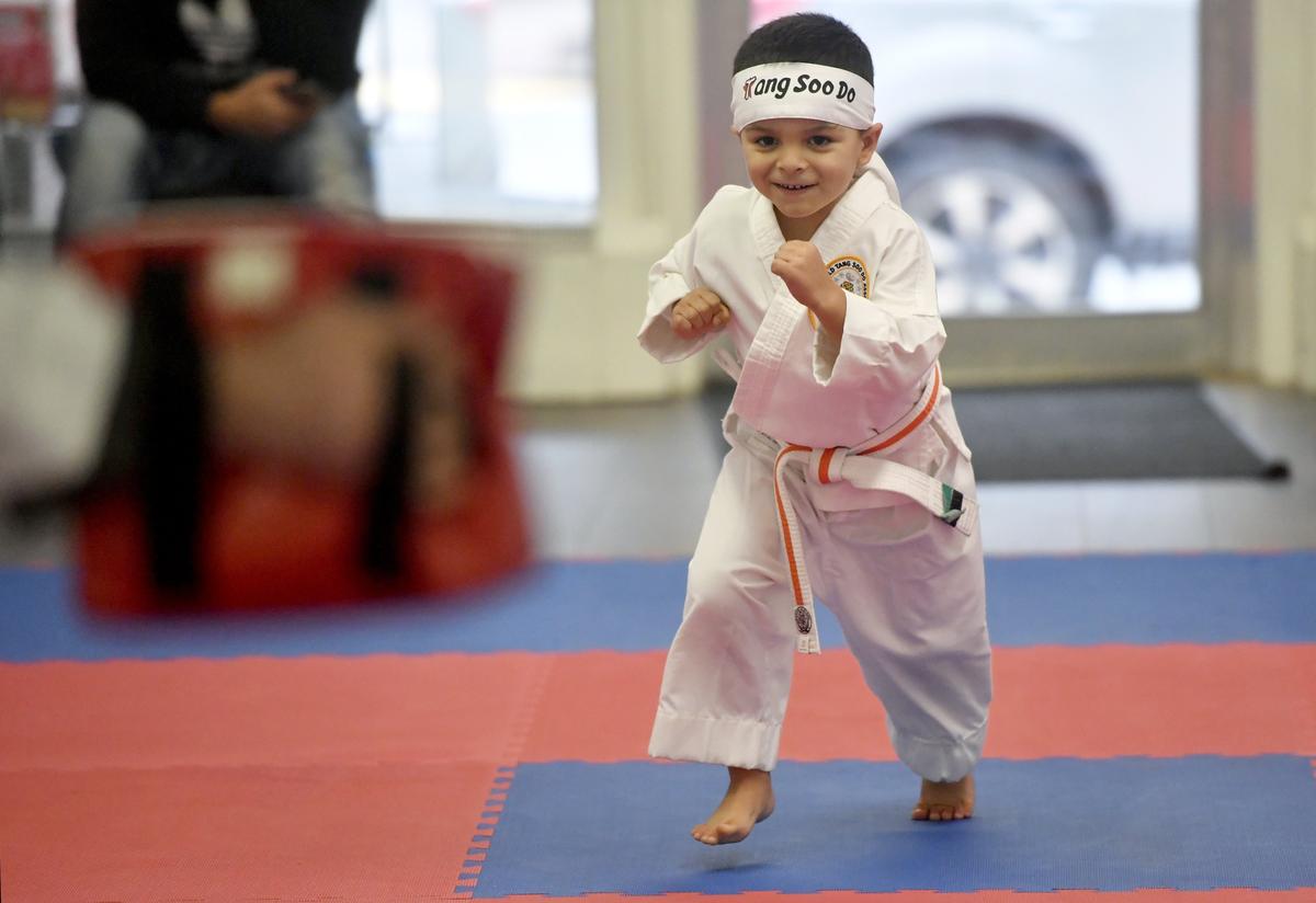 Ignacio Parra, 4, runs to do a jump kick with Tang Soo Do Master Terry Summers at Summers Martial Arts on Monday.