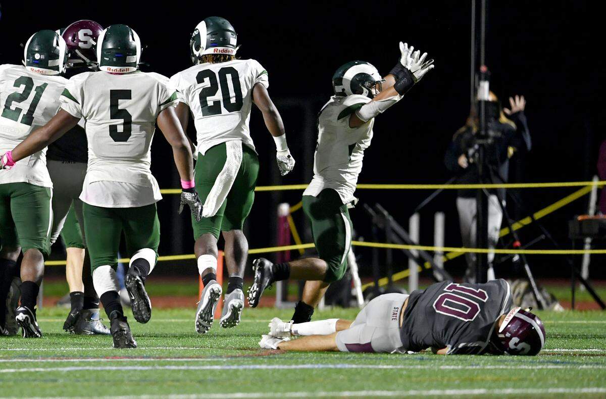 Central Dauphin celebrates their fumble recovery touchdown as State College’s Brady Dorner lays on the field in the fourth quarter of the game on Friday, Oct. 11, 2019.