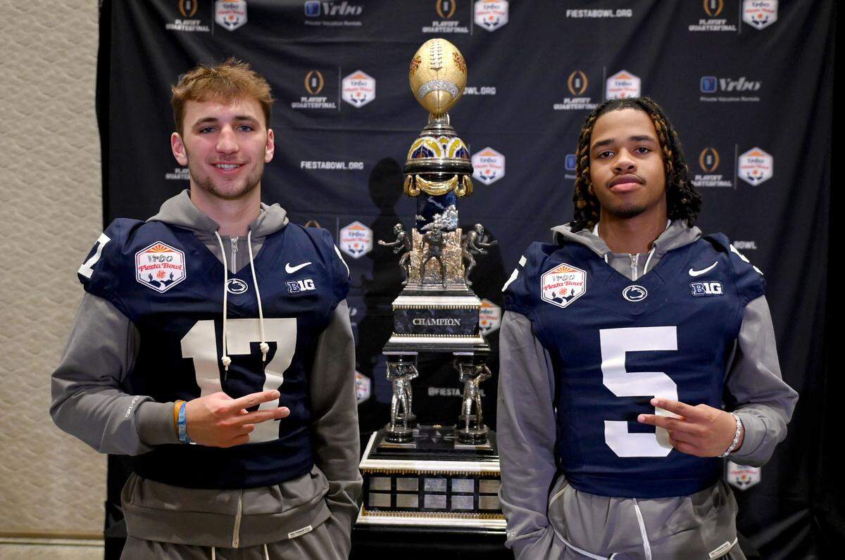 Penn State quarterback Ethan Grunkemeyer and wide receiver Omari Evans pose for a photo with the Fiesta Bowl trophy during media day on Sunday, Dec. 29, 2024.
