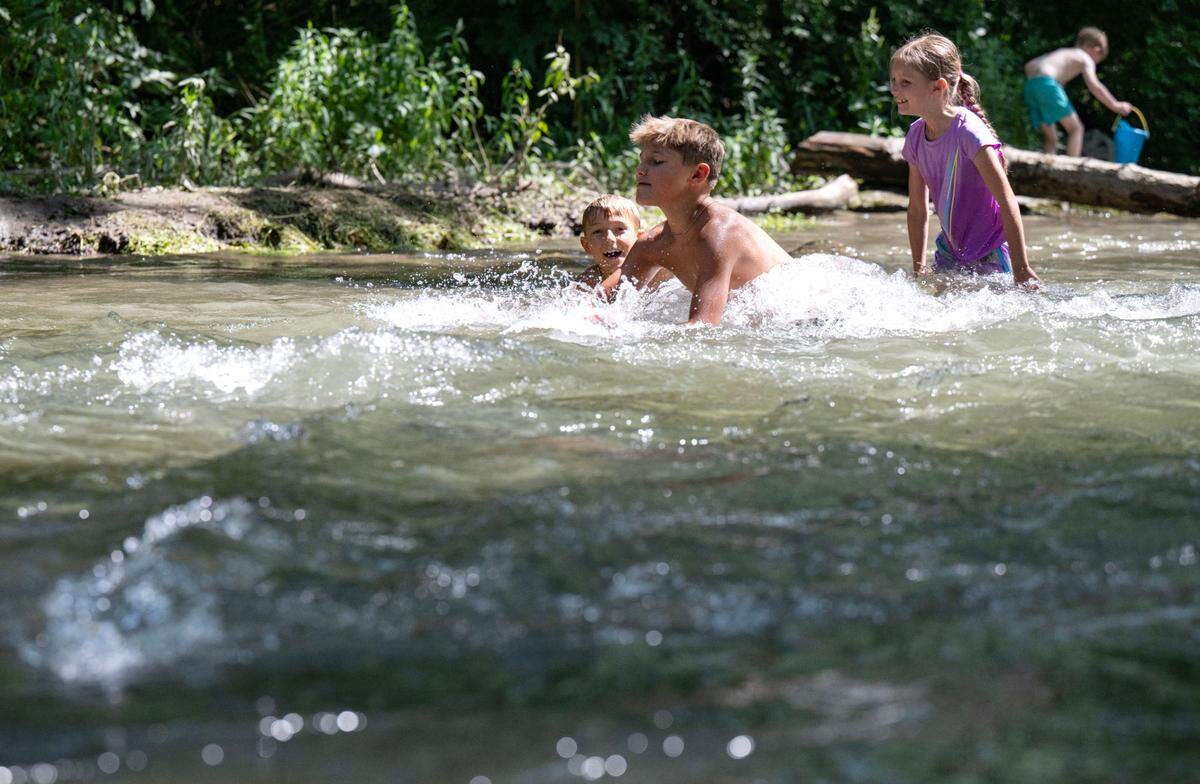 Parker Boal splashes in the creek as he plays with his brother Greyson and cousins Peyton at Spring Creek Park to cool off on Monday, June 23, 2025.
