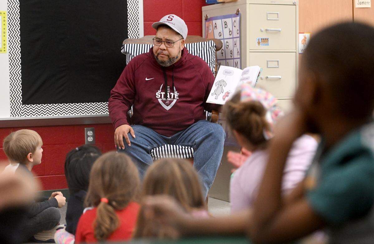 Army veteran Rick Ortiz reads a book to a kindergarten class at Park Forest Elementary School on Friday.