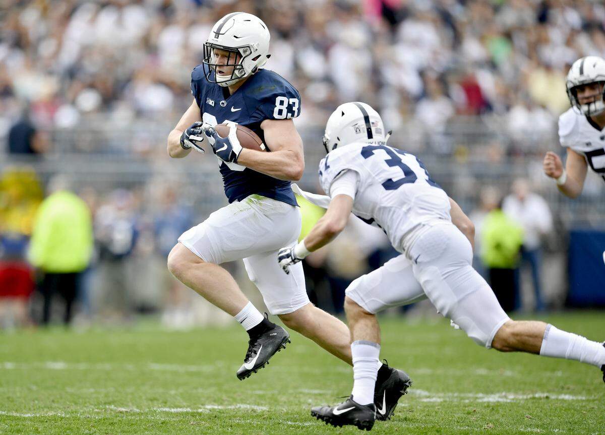 Penn State tight end Nick Bowers runs with the ball ahead of safety Drew Hartlaub during the Blue-White game on Saturday, April 13, 2019.