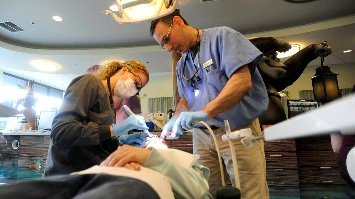 Dental Hygenist Jennifer Troutman and dentist Ron Brungo give Camryn Shipe, 9, a cleaning during Centre Volunteers in Medicine’s Give Kids a Smile day in April 2015.

