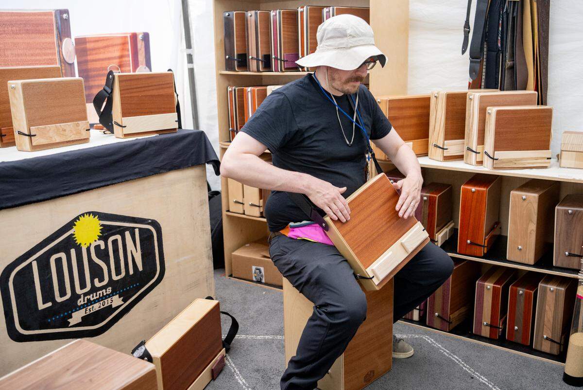 Carson Cashman plays one of the CajonTab drums made by he and his father in their booth Louson drums at the Central Pennsylvania Festival of the Arts on Thursday, July 14, 2022.