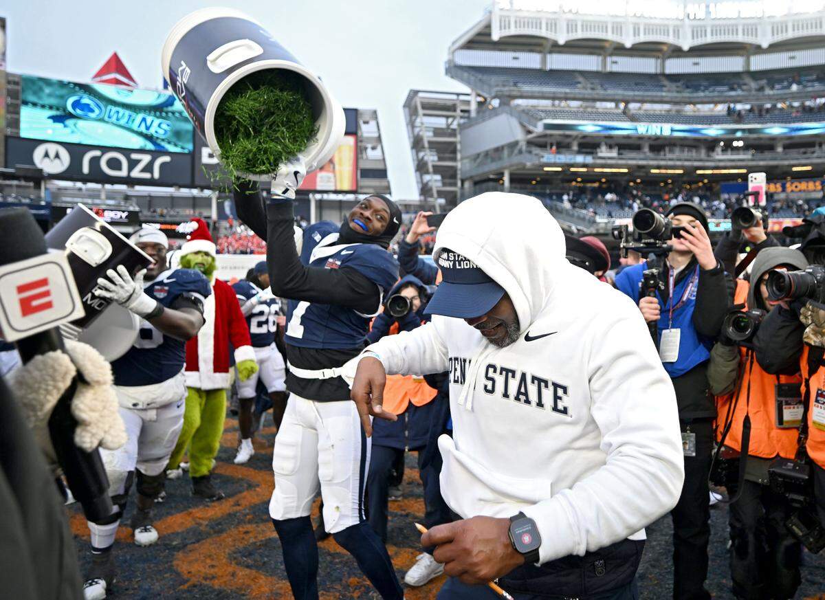 Penn State interim coach Terry Smith gets a cooler of grass dumped on him by cornerback Zion Tracy after the win over Clemson in the Pinstripe Bowl at Yankee Stadium on Saturday, Dec. 27, 2025.