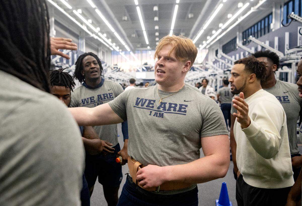 Teammates crowd around Penn State defensive tackle Jordan van den Berg to congratulate him after he did a set of squats at the max-out lifting session on Thursday, March 2, 2023.
