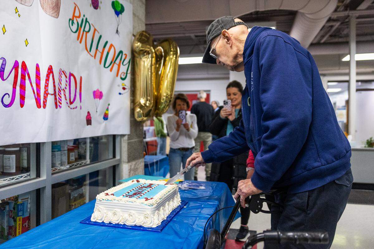 Maynard Kohler, a daily swimmer at the YMCA in State College, cuts the cake during his 100th birthday party on Friday, Jan. 23, 2026 in State College.