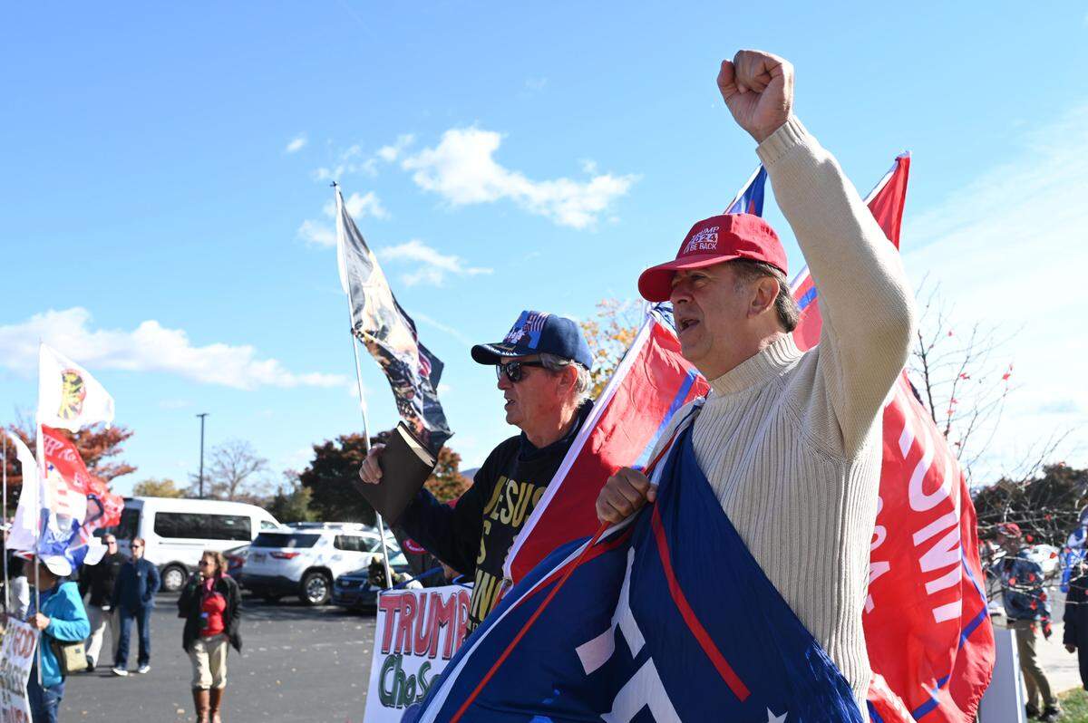 Pascal Hochester, right, and Ted O’Frady, left, chant outside the Bryce Jordan Center during a Trump rally on Saturday, Oct. 26, 2024.