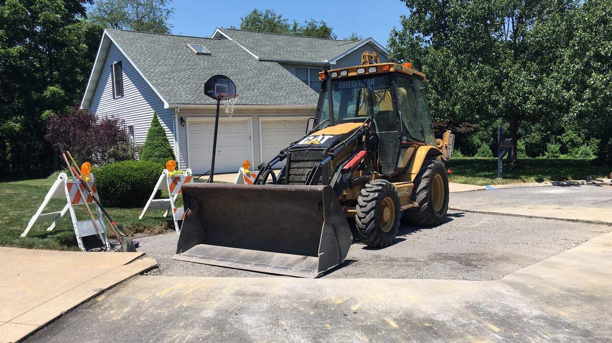 A bulldozer sits atop a freshly filled sinkhole in Ferguson Township on Tuesday. The hole opened up Saturday along Conover Lane, where it broke a water line, township road supervisor Steve McDonald said.