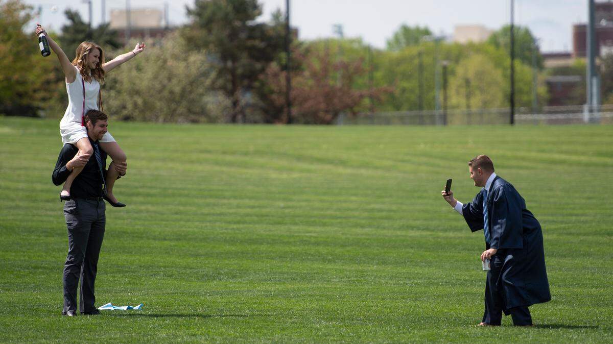 Matthew Kovaleski holds Casey Barnes on his shoulders as Matthew Dolan takes a photo of them in front of Beaver Stadium on May 6 in State College.