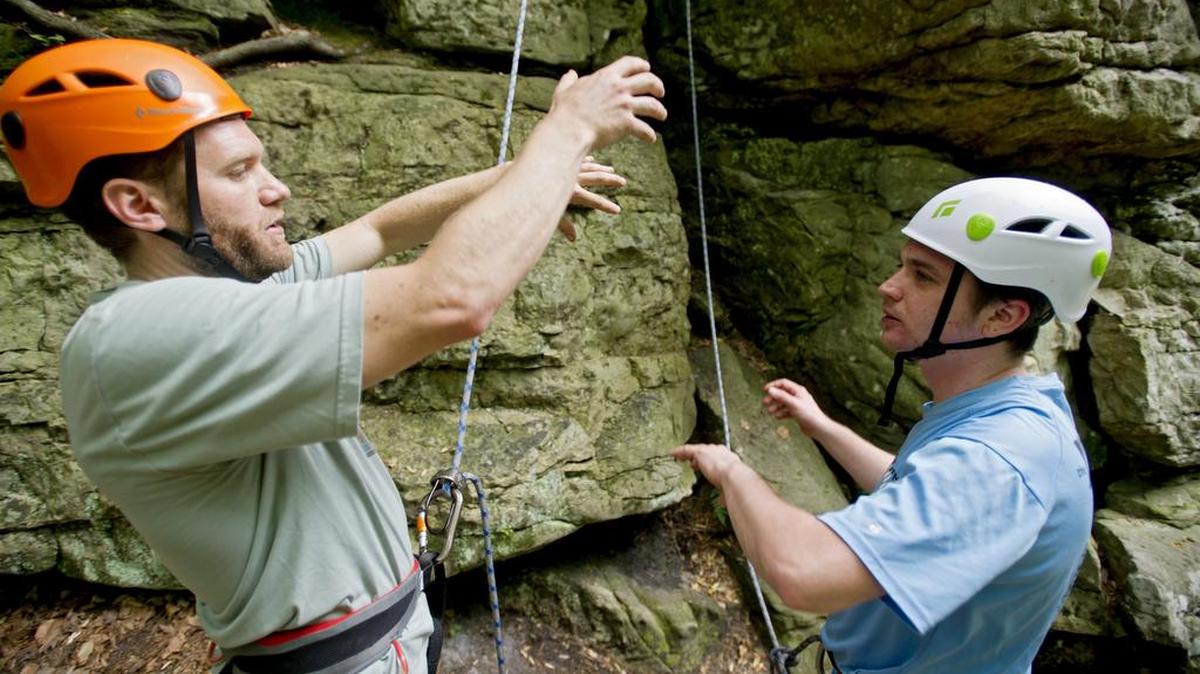 Dave Gantz, left, gives suggestions to Eric Wagner how to conquer a rock face during a beginning rock climbing session on June 8, 2014, with Allegheny Outdoors Institute at Donation Rocks.