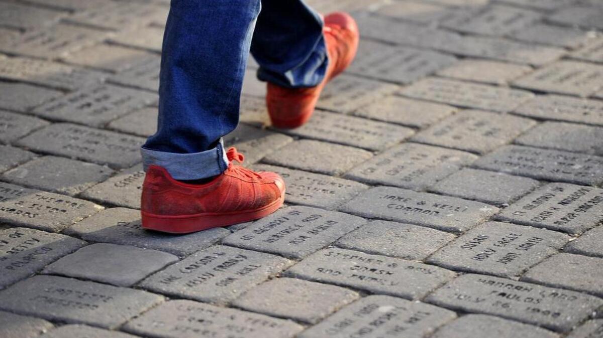 A pedestrian walks across the pavers engraved with donors names on Feb. 29. The State Theatre in downtown State College is selling pavers on the sidewalk to raise money for the theater.