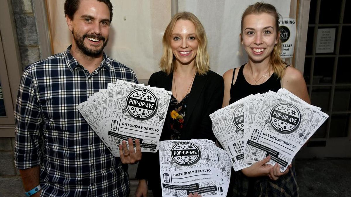 Brad and Andrea Groznik and Victoria Babb promote Pop-Up Ave outside of The State Theatre on Thursday.