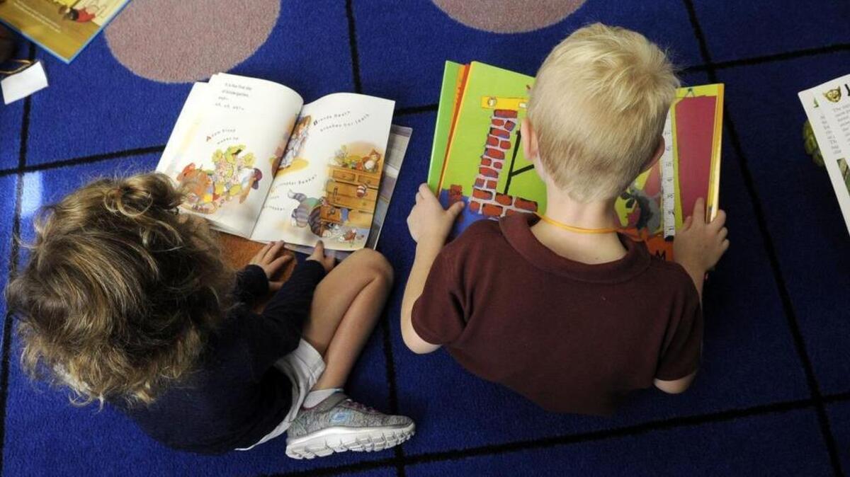 Kindergartners Claire Baron, left, and Micha Hall read books during reading time on Thursday at Grace Lutheran Preschool and Kindergarten.