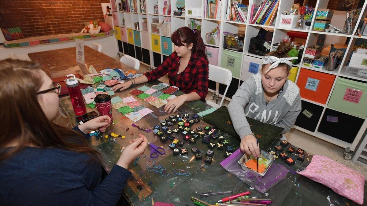 From left, Stormbreak residential child care worker Ashley Garbrick works with Kayla Garcia and Destiney Butler on craft projects Saturday at The Makery in State College.