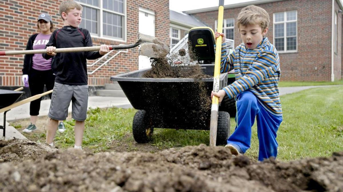 Kindergardener Marshall Shaner helps to shovel dirt to move to the raised beds outside of Ferguson Township Elementary School on Wednesday.