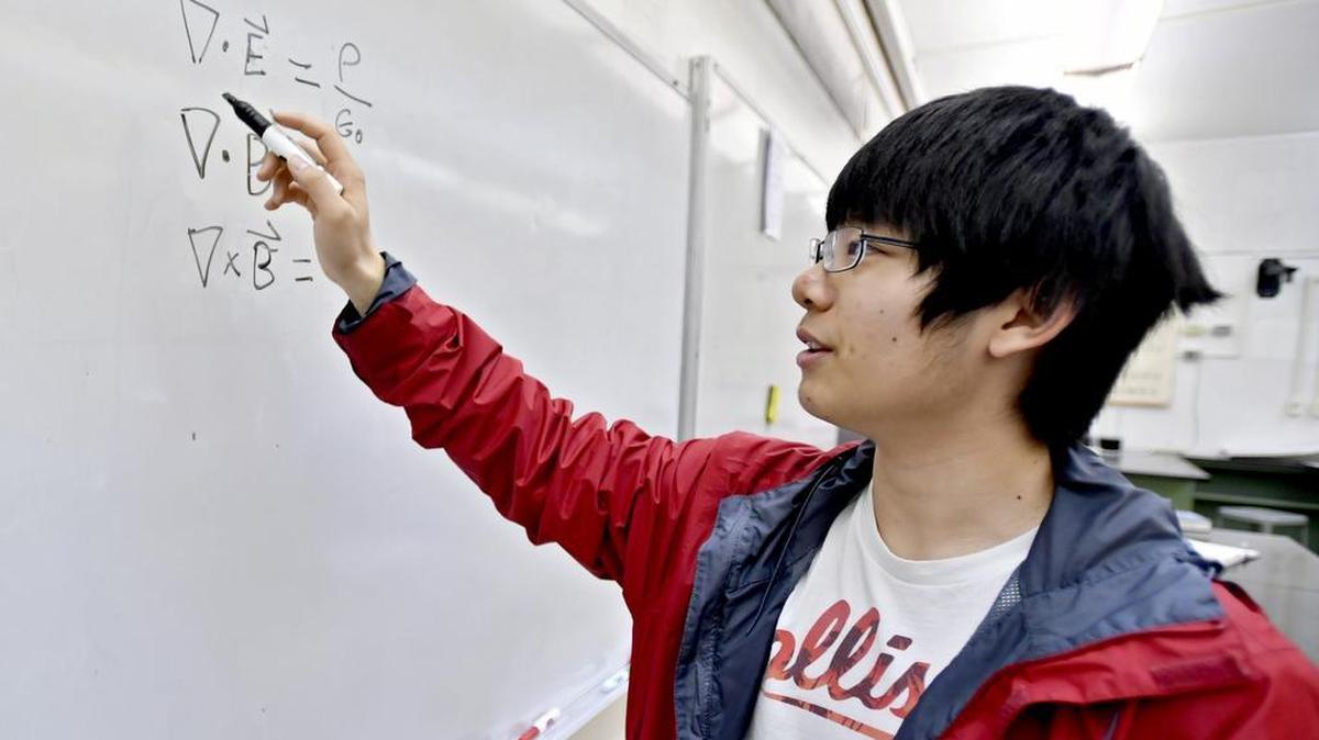Vincent Liu writes Maxwell’s Equations on a white board, though you usually can think them through in his head. Liu is a student at State High who was selected for the 2016 U.S. Physics Team.