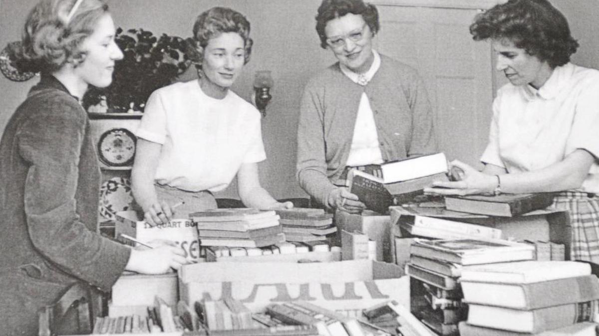 In this archive photo from 1962, AAUW members sort books in a dining room of one of their homes.