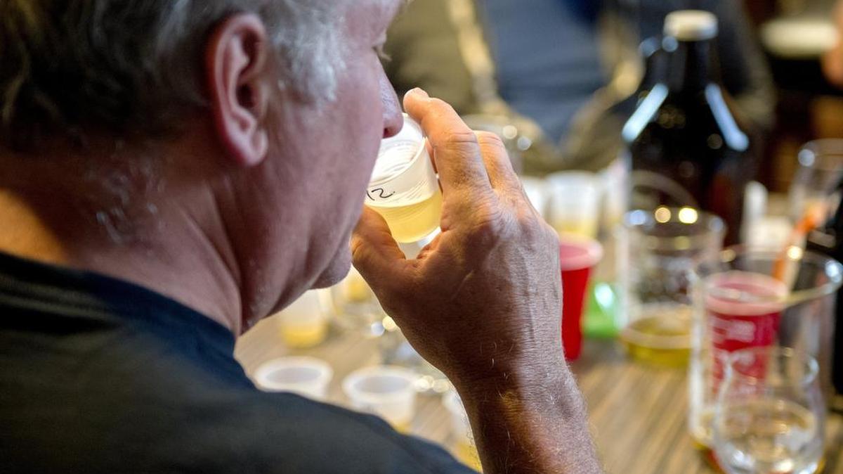 A State College Homebrew Club member smells and tastes a beer sample during a club meeting in July 2016.