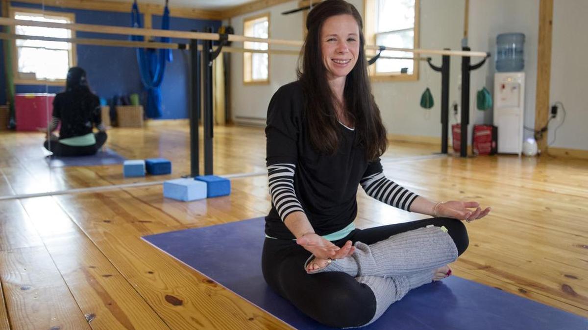 Elizabeth Hay, who donates a portion of her class fees to charity, poses in her yoga studio in Port Matilda on December 11.