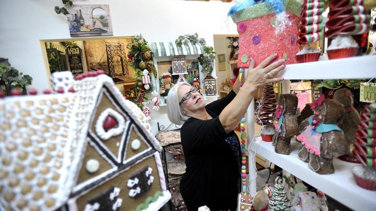 Carol Walker organizes items in her shop, Victorian Rose, in 2013 in Bellefonte.