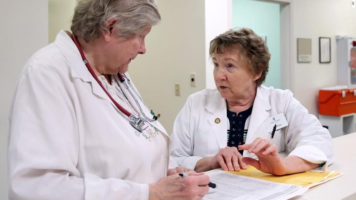 Volunteer family practitioner Barbara Majeroni, left, and volunteer nurse Sharon Bressler go over a chart on May 23 at Centre Volunteers in State College.