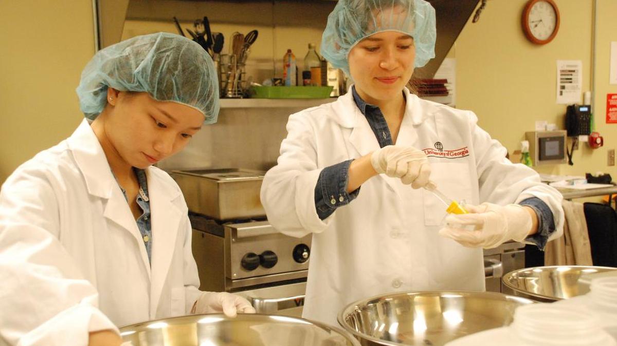 Penn State researchers Qihan Liang and Juliana Fritts prepare the seasonings for carrots in the Metabolic Kitchen in Chandlee Building.