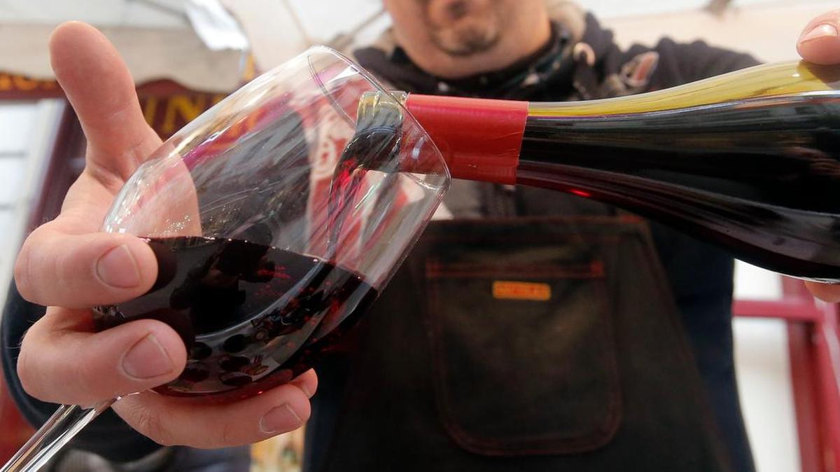 A wine storekeeper pours Beaujolais Nouveau wine in a glass during a presentation in a wine shop in Paris on Nov. 20, 2014.