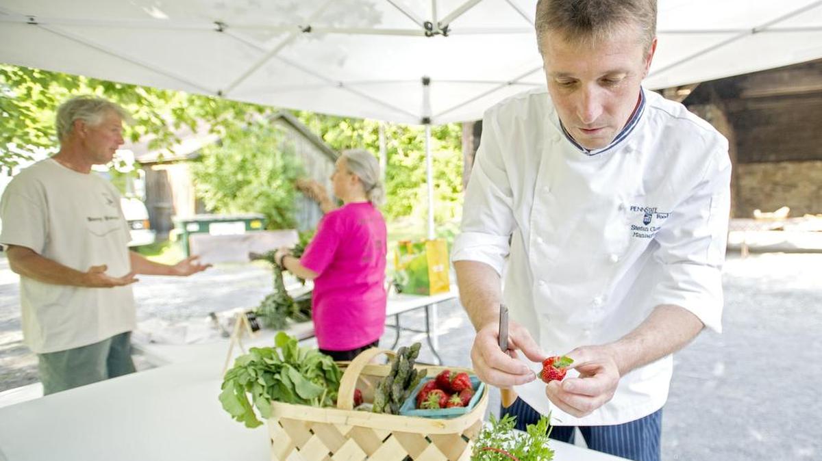 Chef Stephane Gawlowicz puts a piece of mint in a fresh strawberry to taste test at the Lemont Farmers Market on Wednesday.