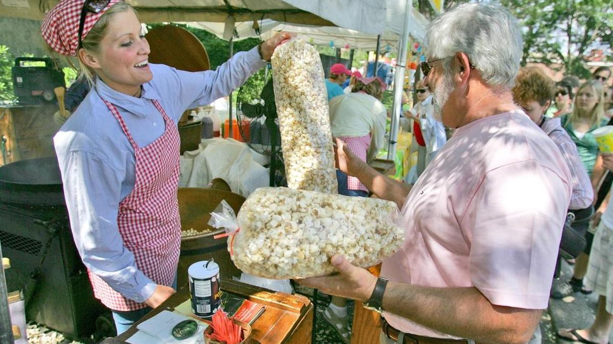 Denny Porta gets a bag of kettle popcorn from Melissa Hanson, of Hanson’s Original Kettle Korn, at the Central Pennsylvania Festival of the Arts in 2007.