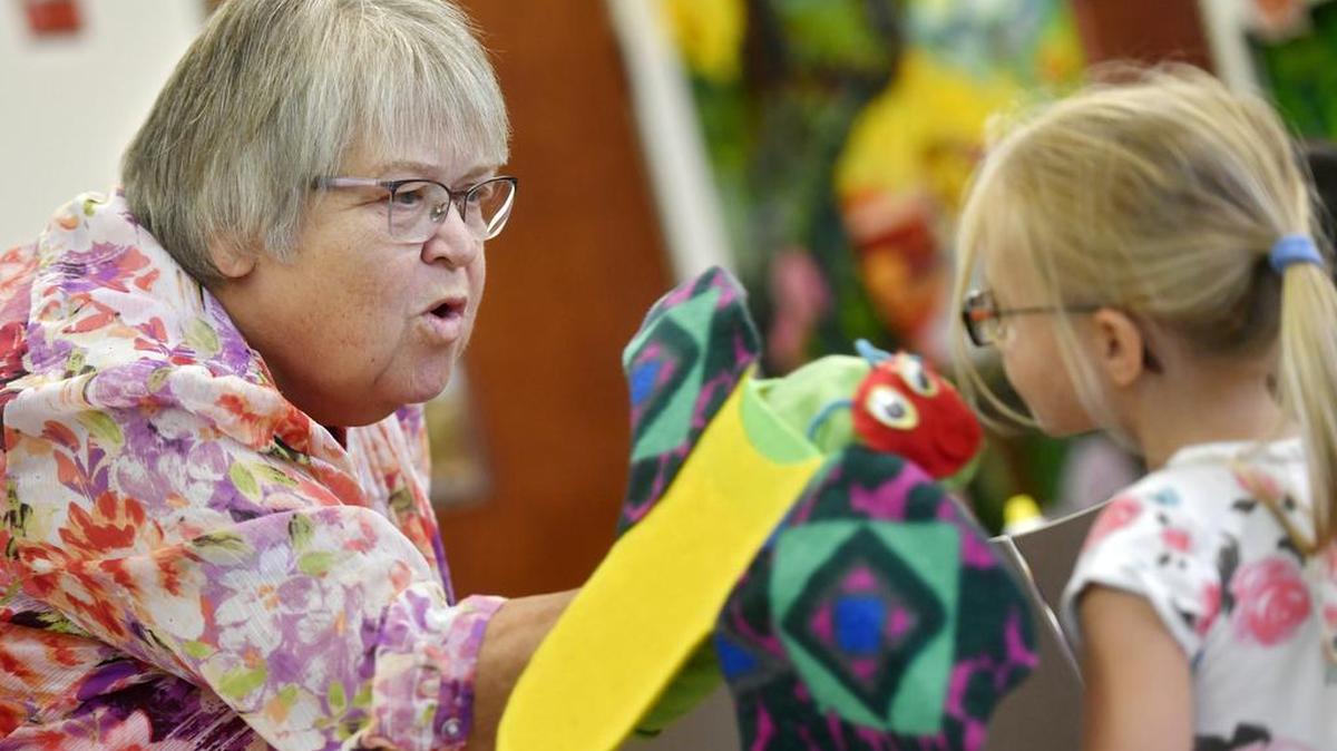 Anita Ditz interacts with a youngster through her butterfly puppet during story time at Schlow Centre Region Library on Saturday.