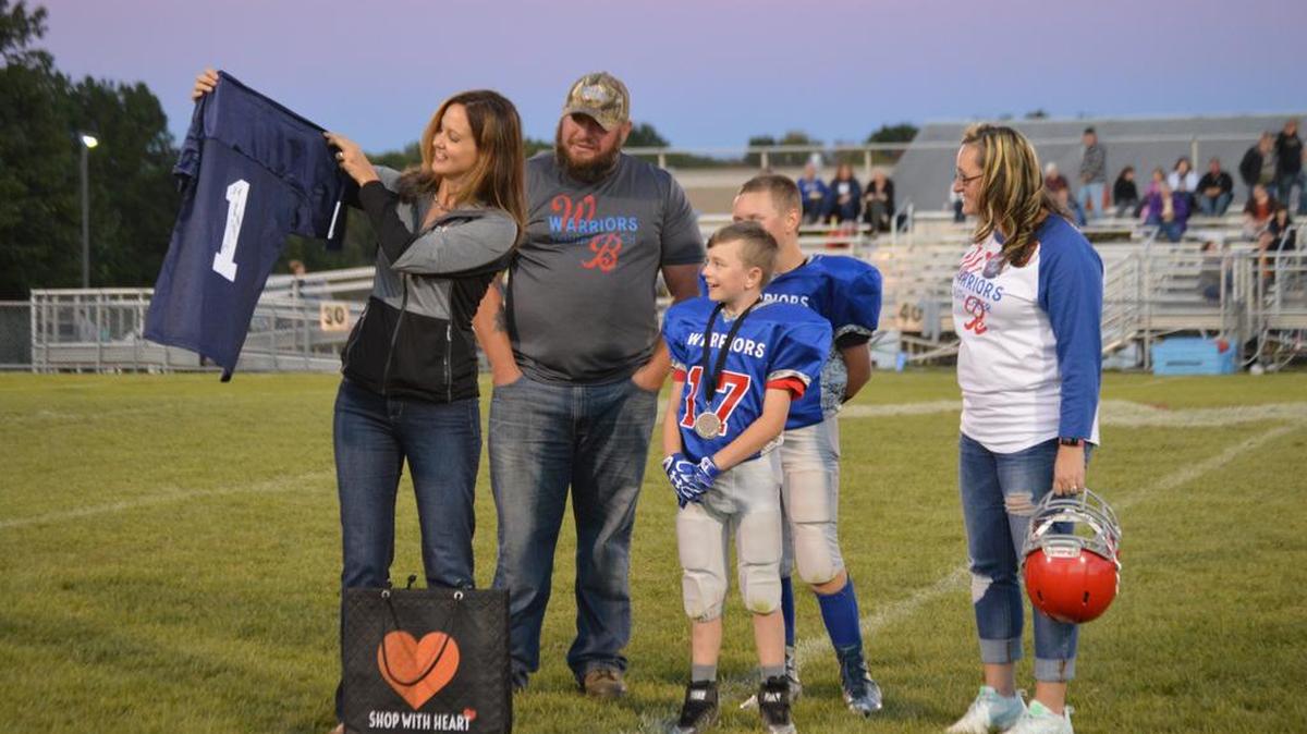 American Heart Association Division Director Brooke Welsh, left, recognizes 10-year-old Logan Liptak as a “Heart Hero” in September. Logan plays for the West Branch Warriors and was presented with a medal and signed Saquon Barley jersey for raising thousands of dollars for the American Heart Association.