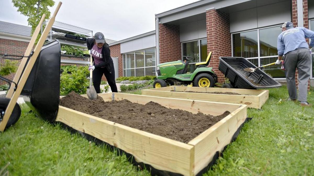 Penn State student Natalie Vercillo helps to spread dirt in the raised beds outside of Ferguson Elementary in May 2016. Raised beds can be attractive and beneficial for growing vegetables and flowers.
