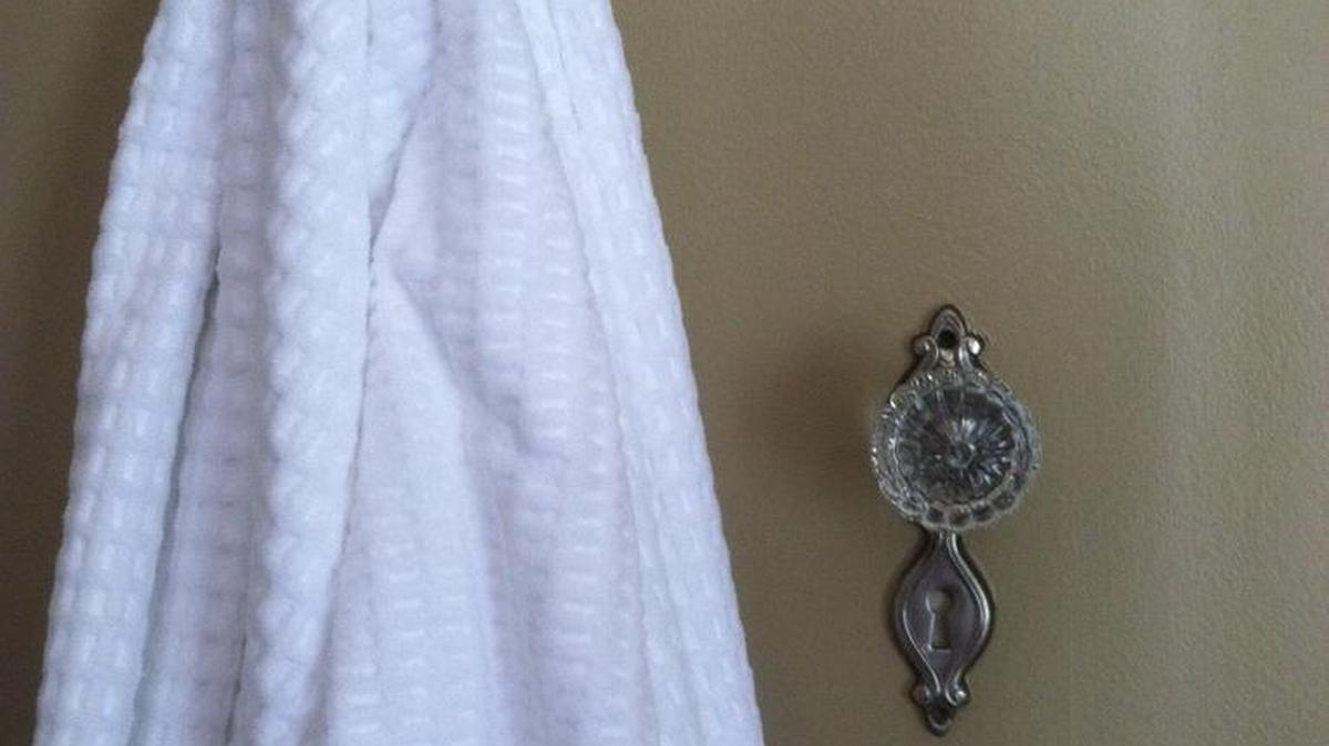 Antique doorknobs can be repurposed in a bathroom to create useful, vintage towel hooks.