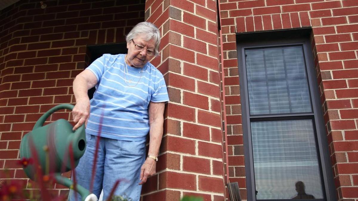 Doris Trueblood waters a tomato plant on Aug. 31 in her garden at Foxdale Village Retirement Community.