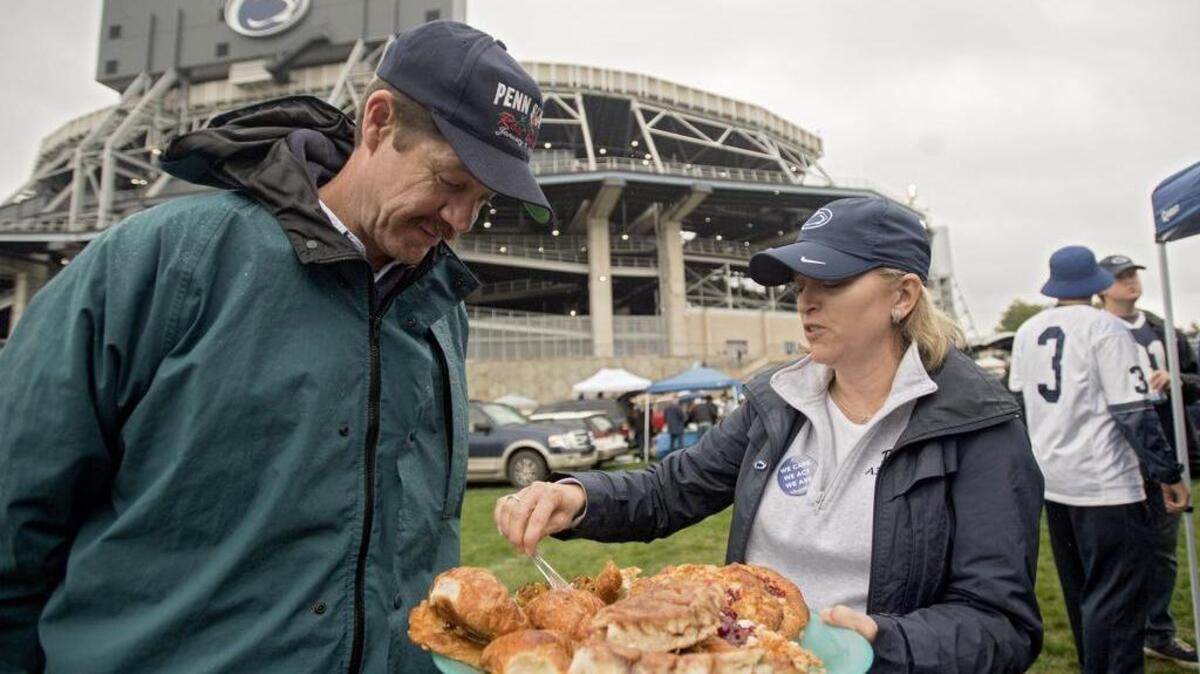 Beth Napolitano offers pastries to friends at her family’s tailgate outside of Beaver Stadium before the football game against Maryland on Oct. 8.