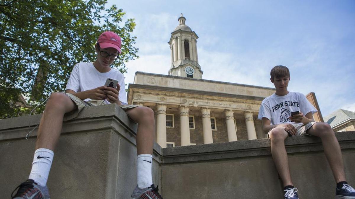 State College brothers Sam Woytowich, left, and Zach Woytowich play Pokemon Go on the steps of Old Main in July.