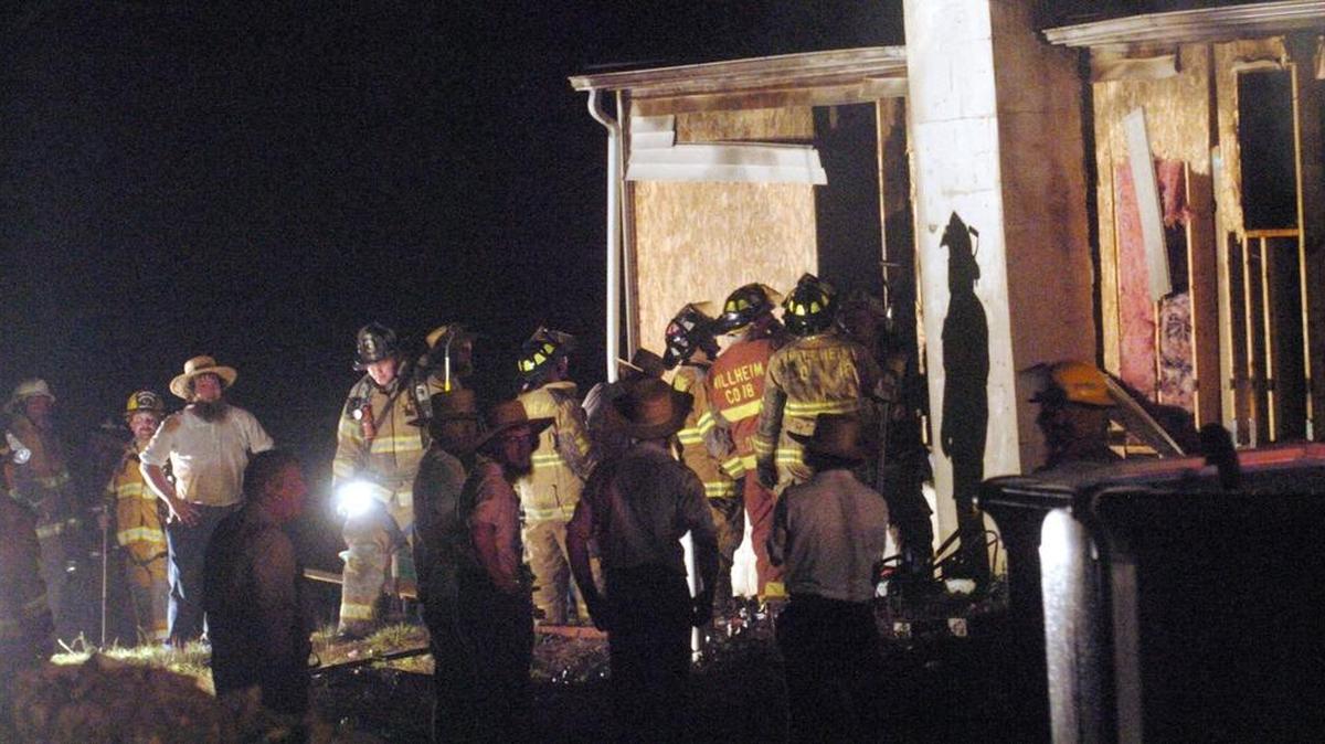 Amish men look on as firefighters work on a fire that gutted an Aaronsburg home on Aug. 24, 2007.