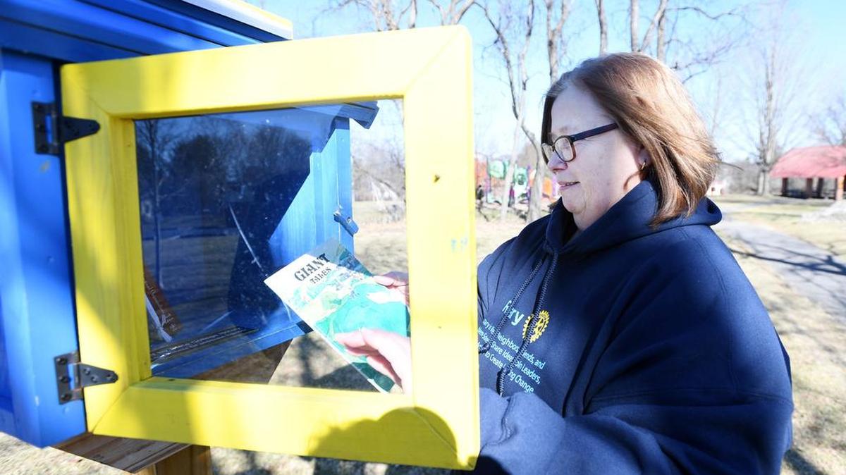 Rotary Club secretary Debbie Fudrow goes through the books from the Little Free Library in Orchard Park on March 4 in State College.