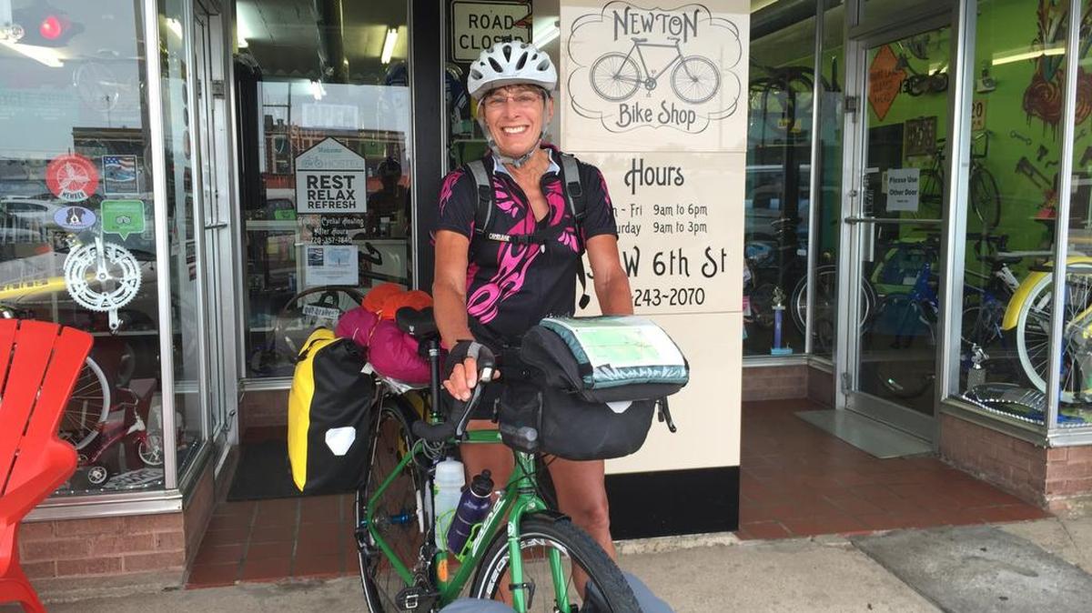 Catherine Grigor poses in front of Newton Bike Shop in Kansas during her 4,000-mile trip across the country last summer.