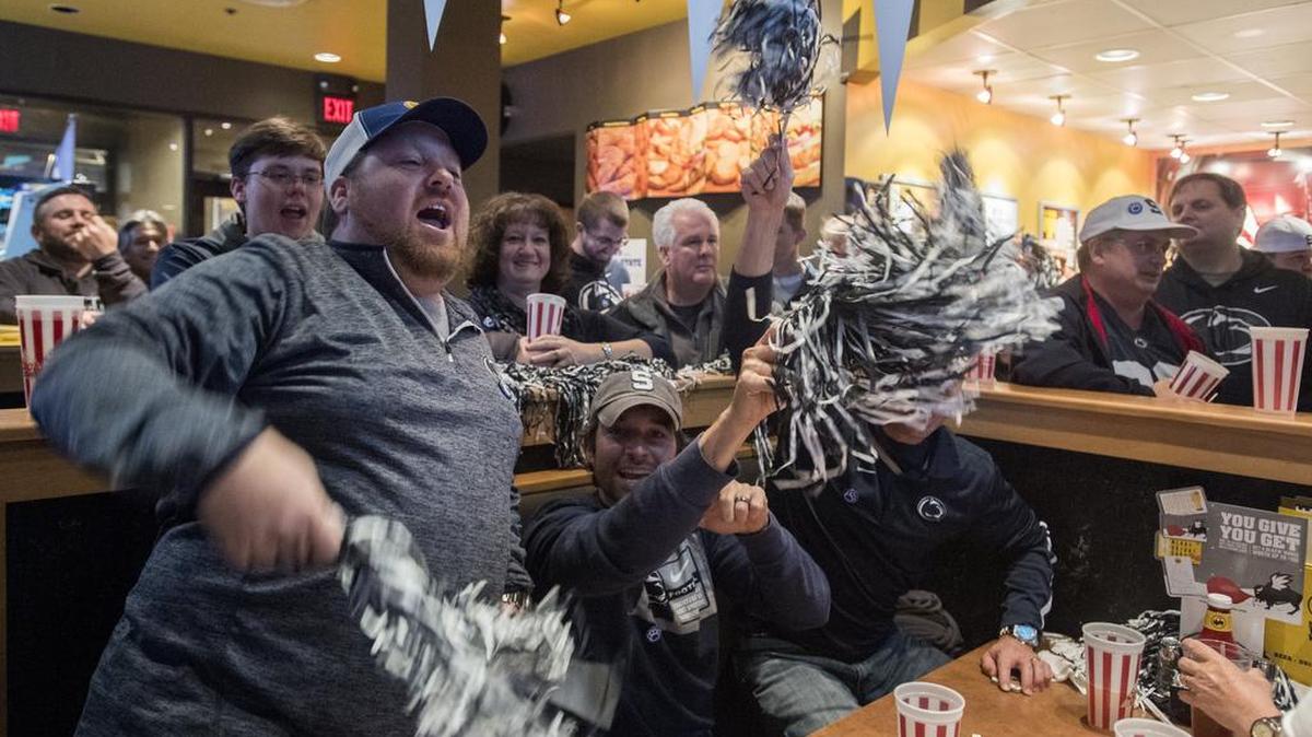Nittany Lions fans cheer during a Penn State alumni association event at Buffalo Wild Wings in Indianapolis during the Big Ten Championship weekend on Dec. 2. Those who have been waiting for the eatery to come to State College will have to wait longer.